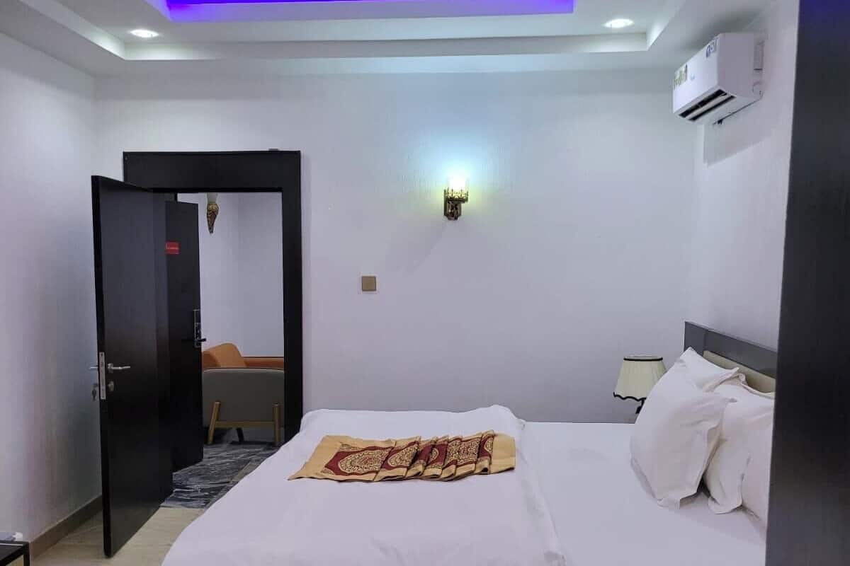 Ein modernes Schlafzimmer mit Bett, Nachttisch und einer Wand-Klimaanlage.