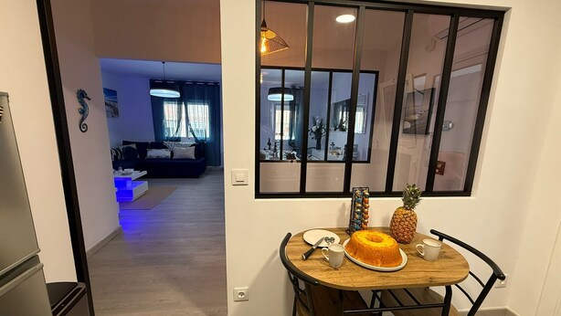 Un comedor con una mesa de madera, sillas, un pastel y una piña.