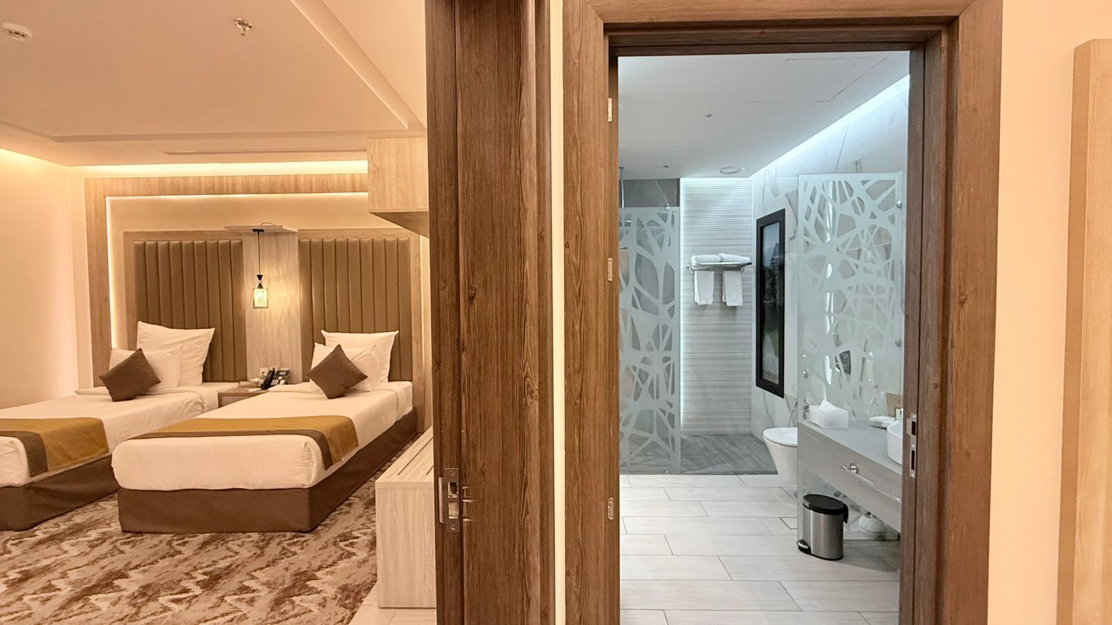 Ein Hotelzimmer mit zwei Betten, einem Badezimmer und einer Treppe zu einer anderen Etage.