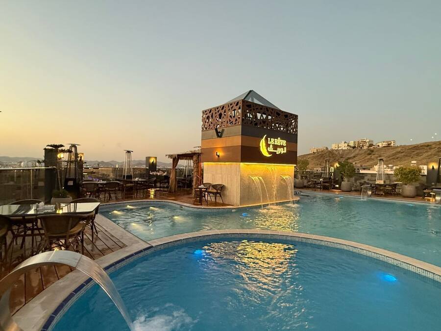 A rooftop pool area with a water feature and seating.