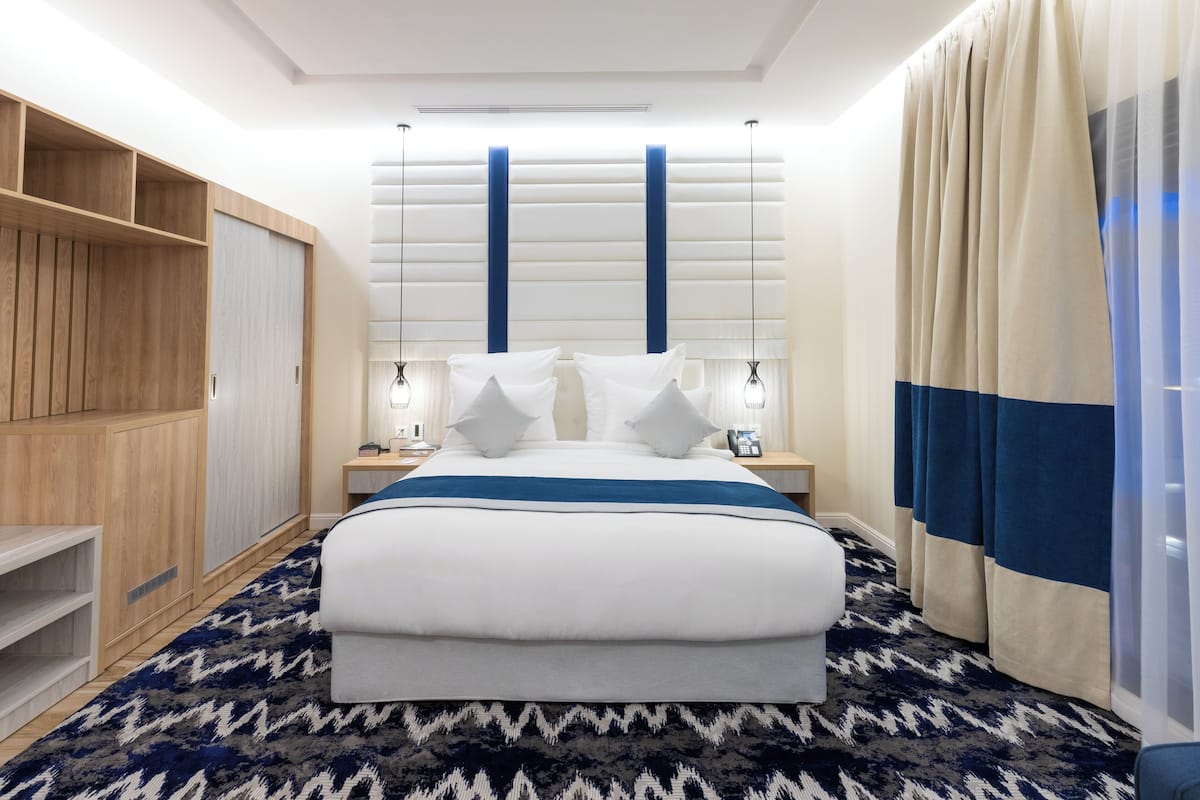 Deluxe King Room | 1 bedroom, in-room safe, blackout drapes, iron/ironing board