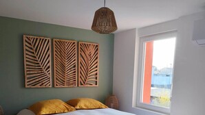A bedroom with a bed, a window, and a plant. - La grange aux fées Amnéville (Amnéville)