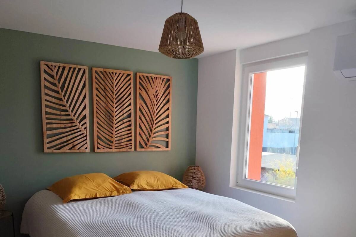 Ein Schlafzimmer mit einem Bett, einem Fenster und einer Pflanze.