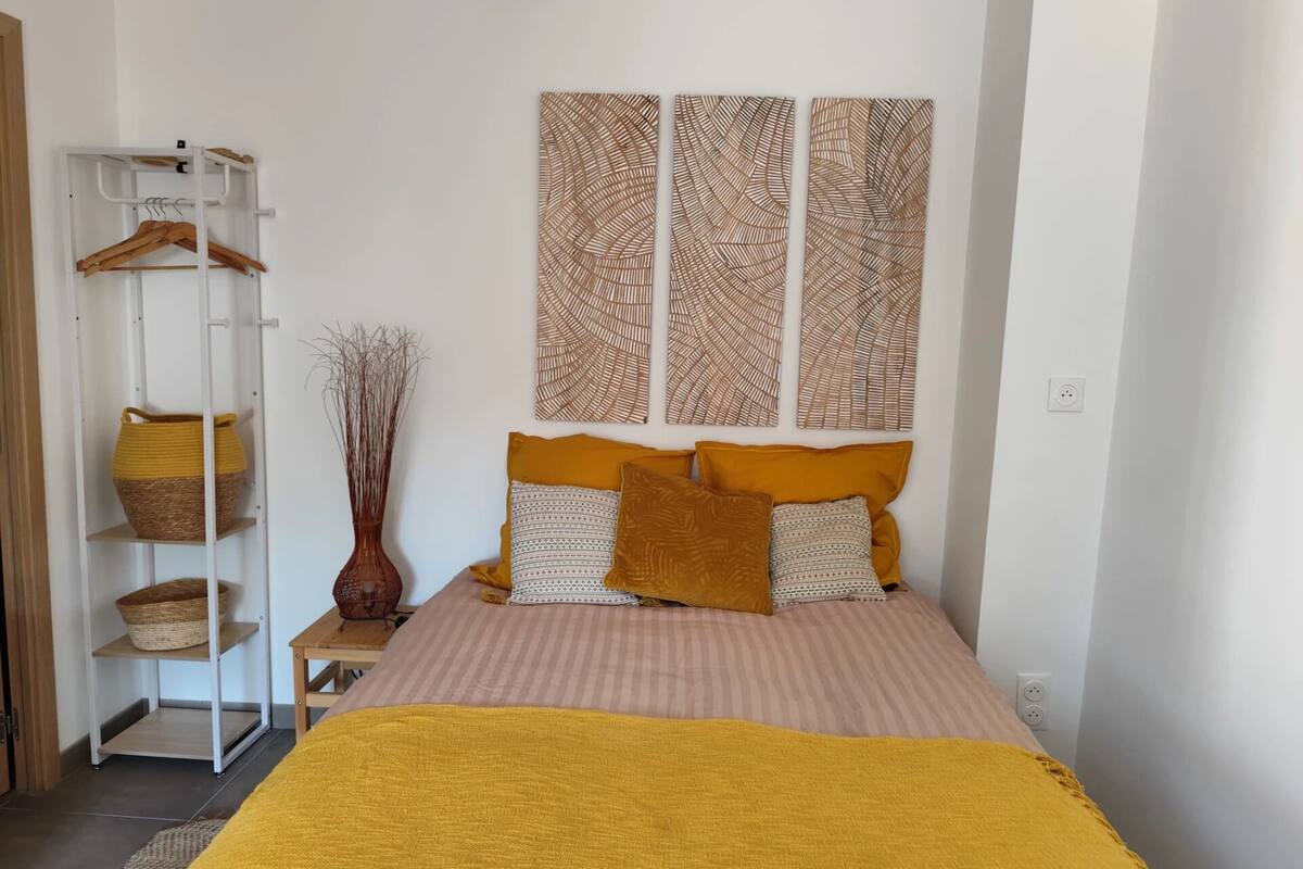 Ein Schlafzimmer mit Bett, Kleiderschrank und einer Zierleiste an der Wand.