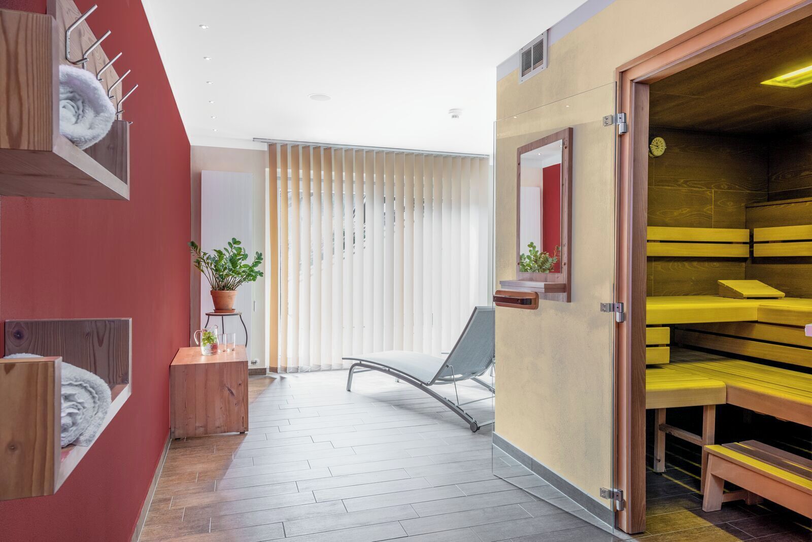 Een modern interieur met een houten bank, een stoel en een potplant.