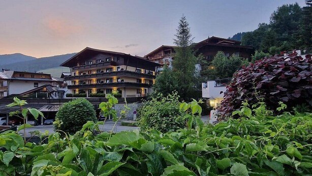 A hotel with multiple floors, balconies, and a mountainous backdrop. - Hapimag Saalbach (Saalbach)