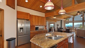 A kitchen with granite countertops, stainless steel appliances, wooden cabinets, and pendant lighting. - Beautiful Home Above Lake Shasta 30 nights minimum (Lakehead)