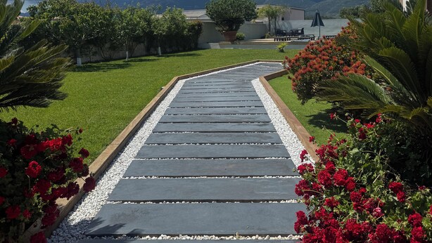 A paved pathway leading to a building with a view of mountains and a lake. - Villa with pool in Lecci (Lecci)