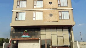 Ein mehrstöckiges Hotel mit einem Schild für "Stella Boutique Hotel" und "The Tyk Cafe".