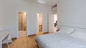 Ein Schlafzimmer mit einem Bett, einem Schreibtisch und einem begehbaren Kleiderschrank.