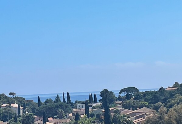 A coastal town with buildings surrounded by trees and a clear view of the sea. - Detached house in quiet neighborhood, hillside views, 10-minute walk to beach. (Cavalaire-sur-Mer)