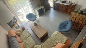 A living room with a sofa, a coffee table, a TV, and a dining area with a cabinet. - Detached house in quiet neighborhood, hillside views, 10-minute walk to beach. (Cavalaire-sur-Mer)