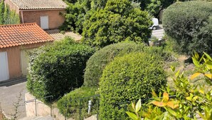 A residential area with terraced houses, a narrow street, and lush greenery. - Detached house in quiet neighborhood, hillside views, 10-minute walk to beach. (Cavalaire-sur-Mer)