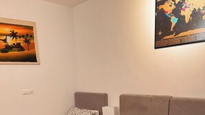 Un dormitorio con dos camas, una con colcha roja y la otra con estampado.