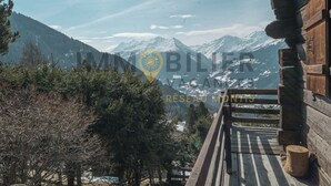 A wooden cabin with a wooden deck overlooking snow-capped mountains. - A charming chalet with a parking space, rustic yet practical, spread over two floors, with a magnifi (St-Luc)