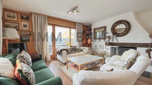 A cozy living room with a green sofa, white armchairs, a coffee table, and a fireplace. - Situé à l'entrée du village, à proximité immédiate du bus navette et des commerces, ce lumineux et s (St-Luc)