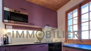 A modern kitchen with purple cabinets, a built-in oven, and a dishwasher. - Idéalement situé, à proximité du vieux village, à 2' à pied du départ du funiculaire. Chalet sur 2 n (St-Luc)