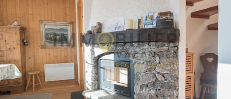 A stone fireplace with a built-in TV, wooden walls, and a rustic decor.