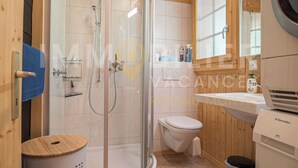 A modern bathroom with a glass-enclosed shower, a white toilet, and a wooden vanity with a sink. - Ce charmant chalet est parfait pour accueillir une famille de 4 personnes. Vous trouverez deux chamb (Chandolin)