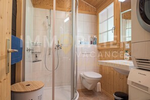 Enjoy a refreshing shower in this bathroom with a glass-enclosed shower area, a toilet, and a sink with a mirror.