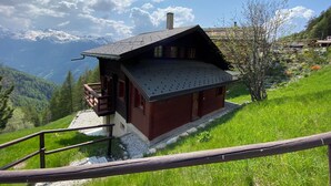 A chalet with a balcony, surrounded by lush greenery and a mountain backdrop. - Ce charmant chalet est parfait pour accueillir une famille de 4 personnes. Vous trouverez deux chamb (Chandolin)