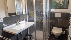 A modern bathroom with a white sink, a glass shower enclosure, and a toilet. - Très beau chalet récent de tout confort situé directement au vieux village, avec un accès aisé. Se l (St-Luc)