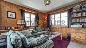 A cozy living room with a sofa set, a coffee table, a lamp, a bookshelf, and a radio. - Charming detached two-storey chalet for 7 (to 8) people. Splendid view of the Imperial Crown with th (St-Luc)