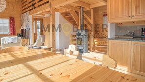 A wooden interior with a dining table, chairs, a staircase, and wooden cabinets. - Très beau chalet chaleureux et confortable, meublé et décoré avec beaucoup de goût. Spacieux et lumi (St-Luc)