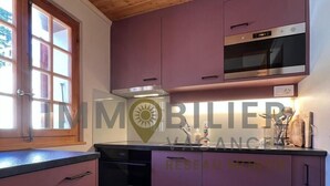 A kitchen with wooden ceiling, purple cabinets, a built-in oven, and a window with a view. - Ideally located near the old village and a 2-minute walk from the funicular railway. Two-storey chal (St-Luc)