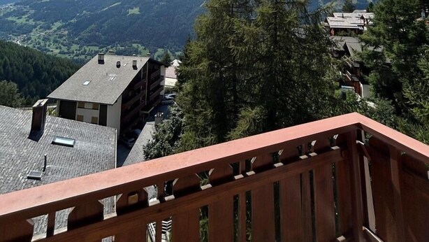 A balcony with a view of mountains and a clear sky. - Idéalement situé, au pied des pistes, en face du funiculaire. Appartement agréable et chaleureux, au (St-Luc)
