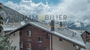 A mountain cabin with a sloped roof, wooden exterior, and multiple windows. - Au pied des pistes, en face du funiculaire et à 5' à pied du centre du vieux village ! Appartement c (St-Luc)