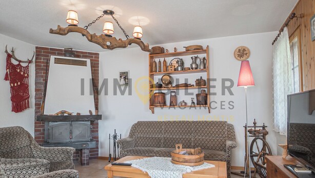 A living room with a fireplace, patterned sofas, a wooden coffee table, and a television. - Appartement pour 5 personnes au rez-de-chaussée situé à seulement 300 mètres des pistes et bénéficia (St-Luc)