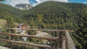 A mountain lodge with a view of a forested mountain and a clear sky. - Appartement pour 5 personnes au rez-de-chaussée situé à seulement 300 mètres des pistes et bénéficia (St-Luc)