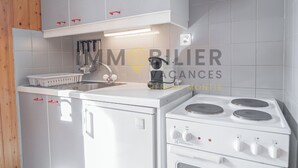 A kitchen with white cabinets, a stove, and a sink.