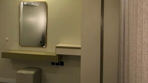 Een moderne badkamer met een grote spiegel, toilet en wastafel.