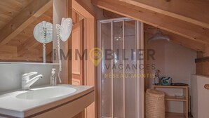 Interior de madera con baño que incluye un lavamanos, dos teléfonos y un box de ducha.