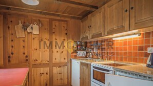 A kitchen with wooden cabinets, a stove, and a sink.