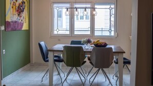 Un comedor con una mesa, sillas y una ventana con vistas a edificios.