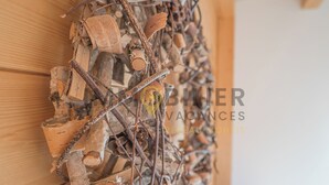 Una pared con un arreglo decorativo de materiales naturales como madera, ramitas y tapones de corcho.