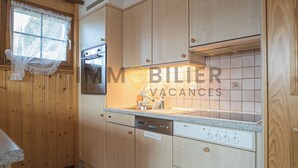 Une cuisine avec des meubles en bois, un lave-vaisselle Bosch et un dosseret carrelé.