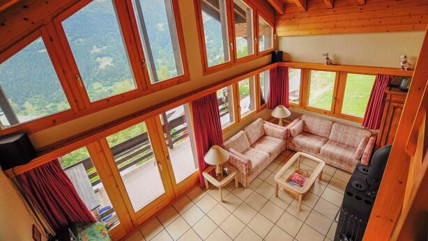 A spacious room with large windows, a sofa set, a coffee table, and a fireplace. - Très beau duplex combles plein sud, vue splendide ! Aisément accessible, à l'entrée du village, à pr (St-Luc)