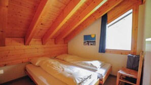 A small, wooden room with two single beds, a wooden chair, and a window with a view. - Très beau duplex combles plein sud, vue splendide ! Aisément accessible, à l'entrée du village, à pr (St-Luc)