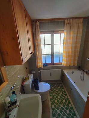 Un baño con inodoro, bañera y lavamanos.