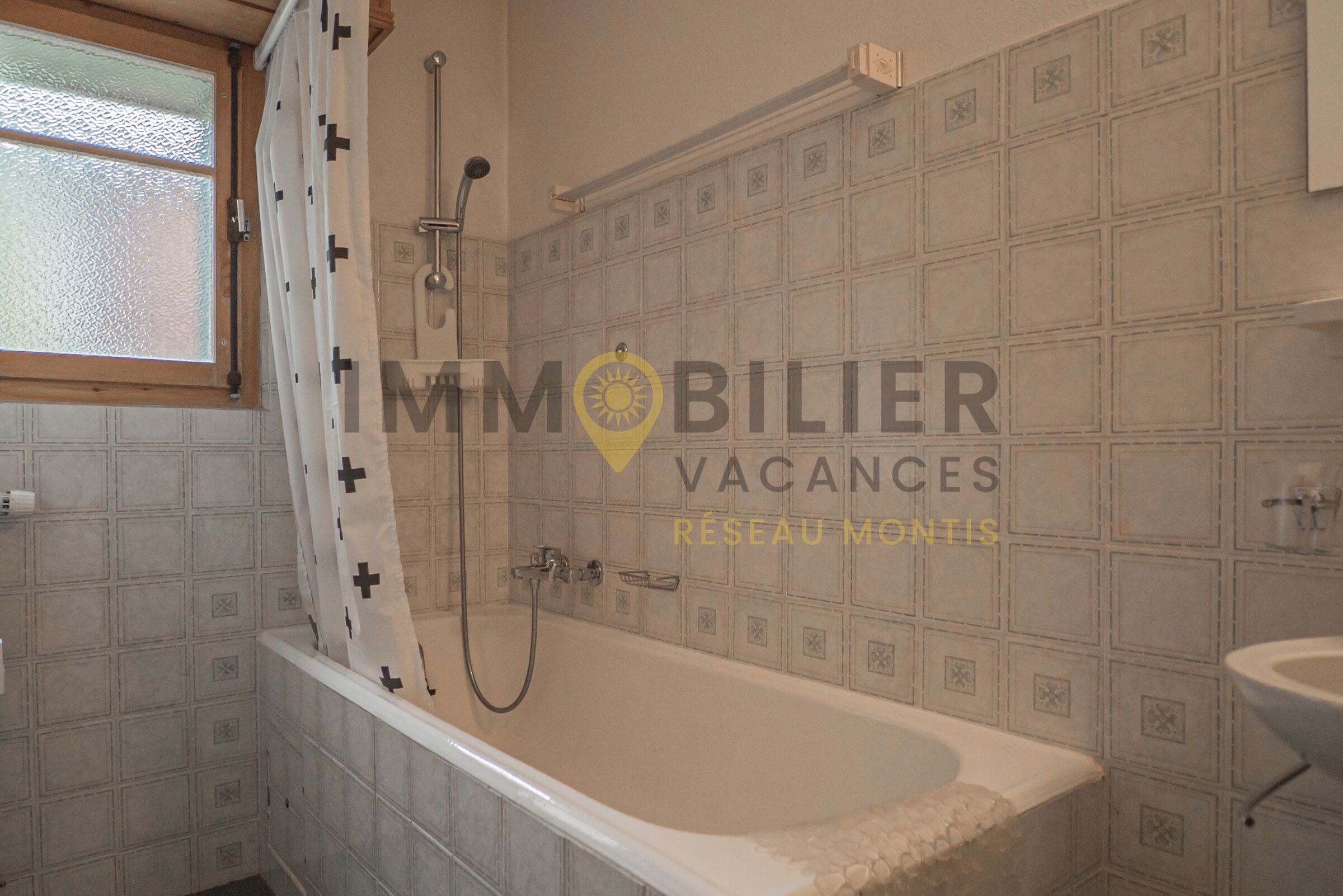 Une salle de bain avec une baignoire, une douche et une fenêtre.