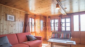A wooden cabin interior with a red sofa, a wooden bench, and a framed picture on the wall. - In the heart of the old village of Chandolin, a charming, authentic apartment, entirely panelled in (Chandolin)