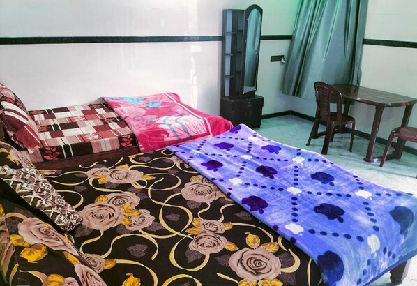 Une pièce comprenant un lit, un miroir, une table et des chaises.
