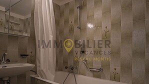A bathroom with a bathtub, a shower, and a sink.