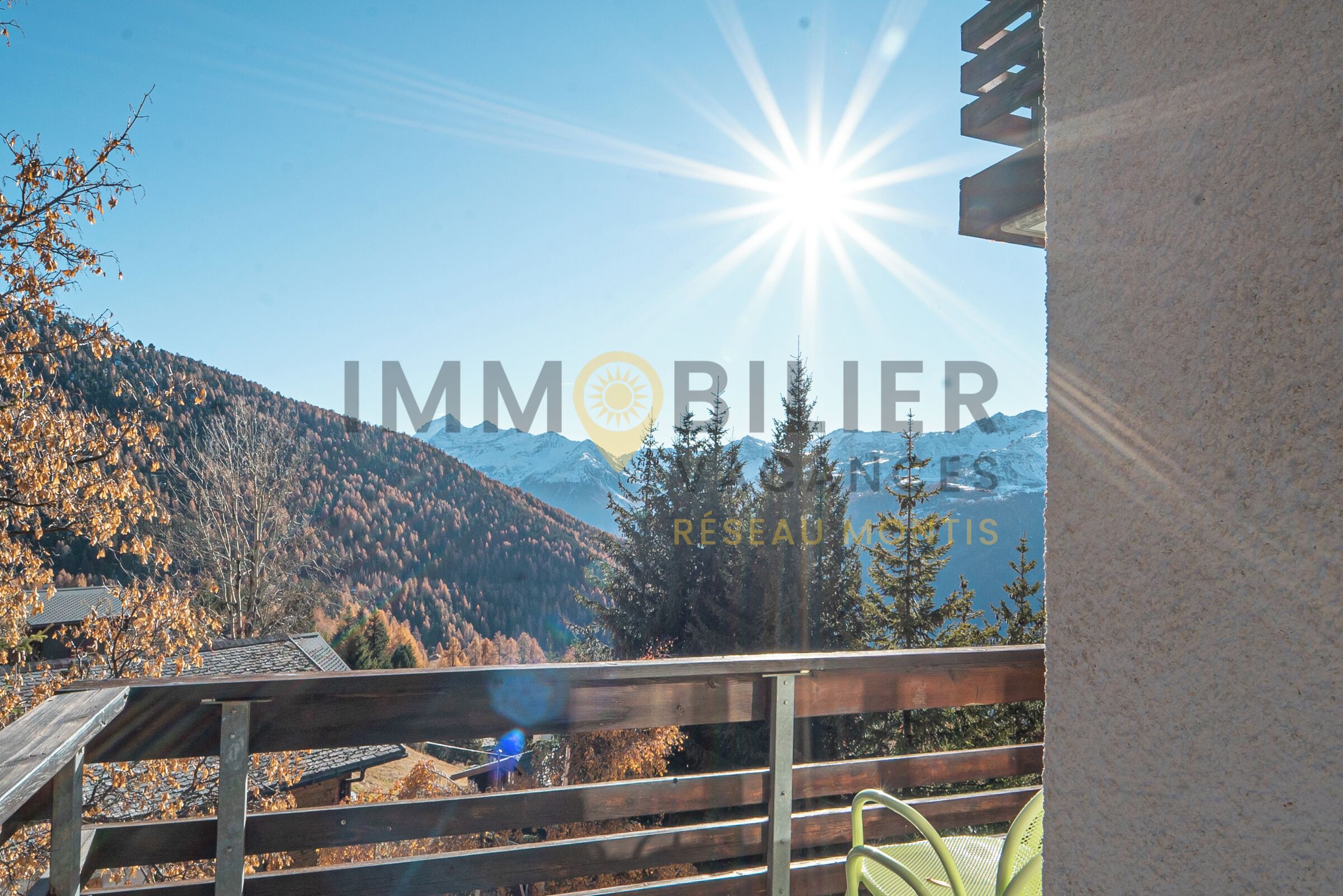 A balcony with a view of mountains and autumn trees.