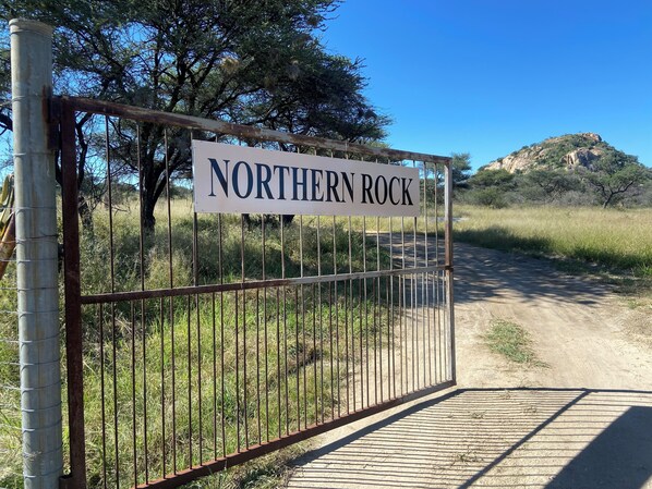 A metal gate with a sign reading "Northern Rock" in a natural setting.