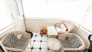 A cozy room with wicker furniture, a toy train, and a checkered floor.